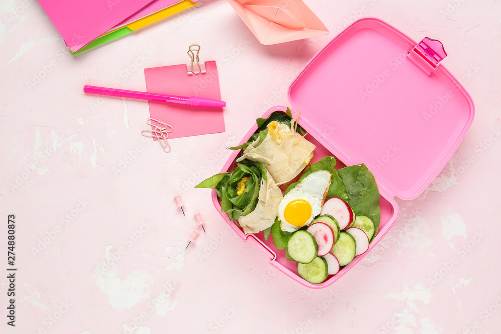 School lunch box with tasty food and stationery on light background School lunch box with tasty food and stationery on light background