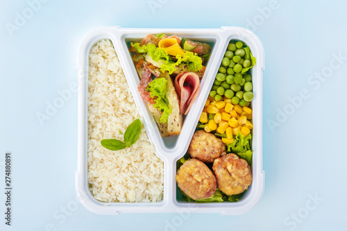 School lunch box with tasty food on light background