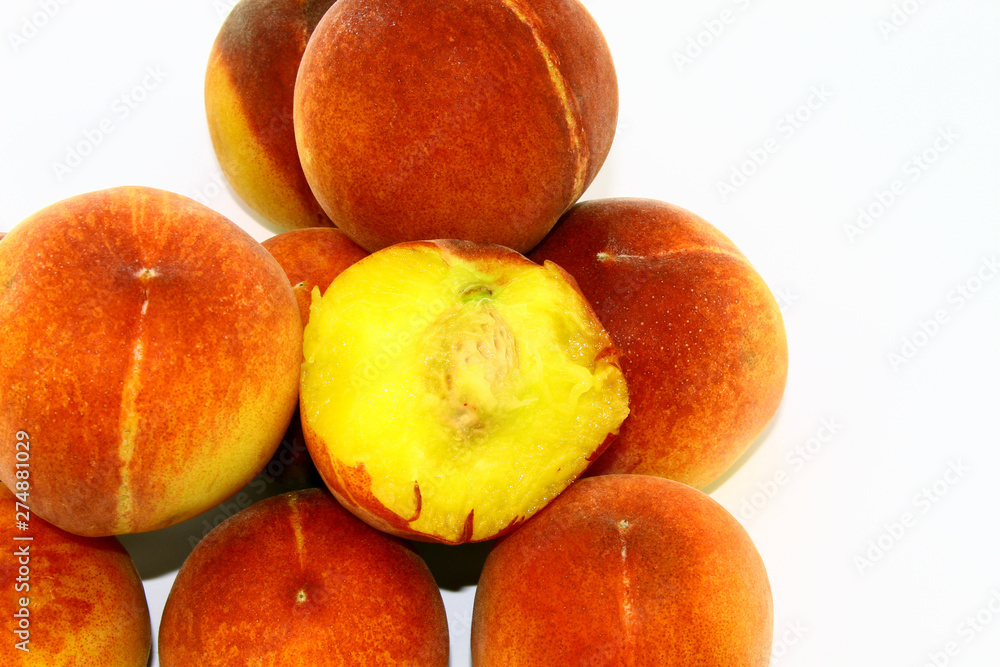 Half-eaten peach to the bone placed among whole peaches on a white background Half-eaten peach to the bone placed among whole peaches on a white background