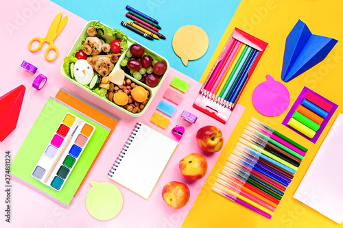 School supplies, colorful stationery, backpack and lunchbox with funny food for kids . Back to school concept lay out