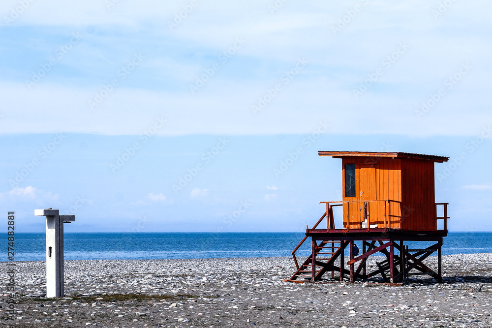 Wooden lifeguard tower. Orange rescue tower with blue sea and sky on background. Wooden lifeguard tower. Orange rescue tower with blue sea and sky on background.
