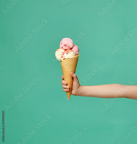 Obraz na płótnie Baby kid hand holding big ice-cream in waffles cone on blue w salonie