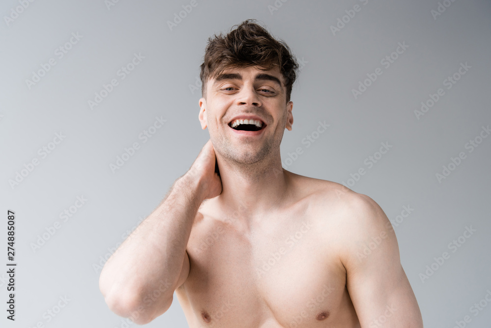 Fototapeta premium smiling shirtless sexy muscular man isolated on grey