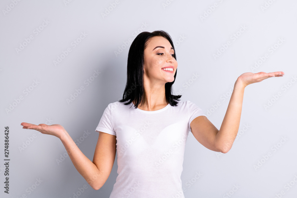 Portrait of her she nice-looking attractive lovely charming cheerful cheery girl holding two objects on palms copy empty blank space ad isolated over light gray pastel background Portrait of her she nice-looking attractive lovely charming cheerful cheery girl holding two objects on palms copy empty blank space ad isolated over light gray pastel background