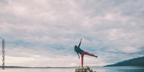 Woman catches balance on the stone. © zhukovvvlad