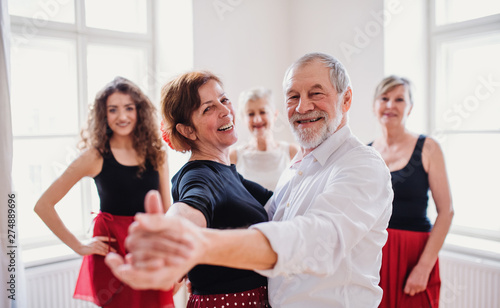 Group of senior people in dancing class with dance teacher.