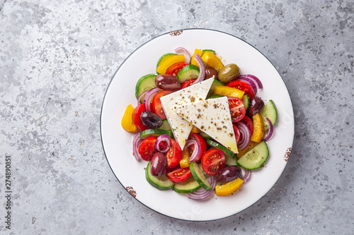 Fresh tomato, cucumber, bel pepper, olives  and feta cheese salad on white plate