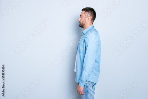 Close up side profile photo amazing he him his guy macho perfect appearance hairstyle look empty space reliable person not smiling think listen wear casual jeans denim shirt isolated grey background