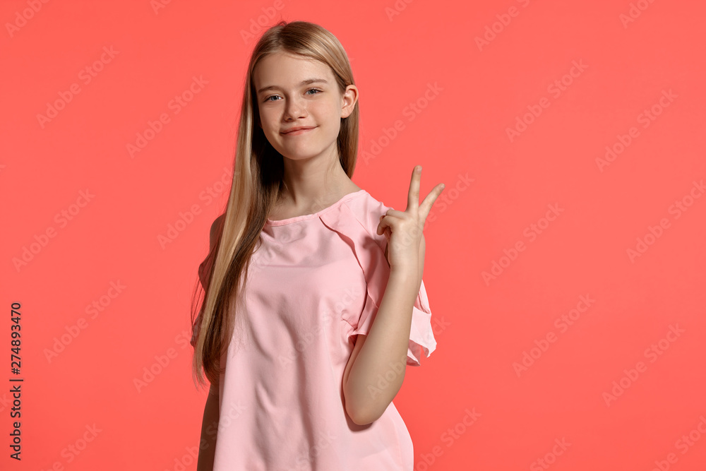 Studio portrait of a beautiful girl blonde teenager in a rosy t-shirt posing on pink background. Studio portrait of a beautiful girl blonde teenager in a rosy t-shirt posing on pink background.