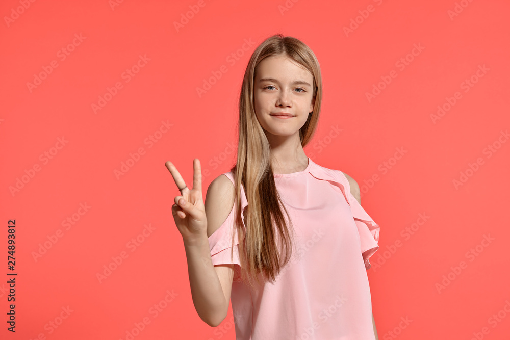 Studio portrait of a beautiful girl blonde teenager in a rosy t-shirt posing on pink background. Studio portrait of a beautiful girl blonde teenager in a rosy t-shirt posing on pink background.