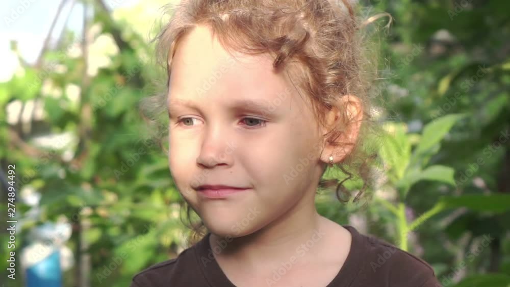 Portrait of a little girl in a rural garden. Slow motion Portrait of a little girl in a rural garden. Slow motion