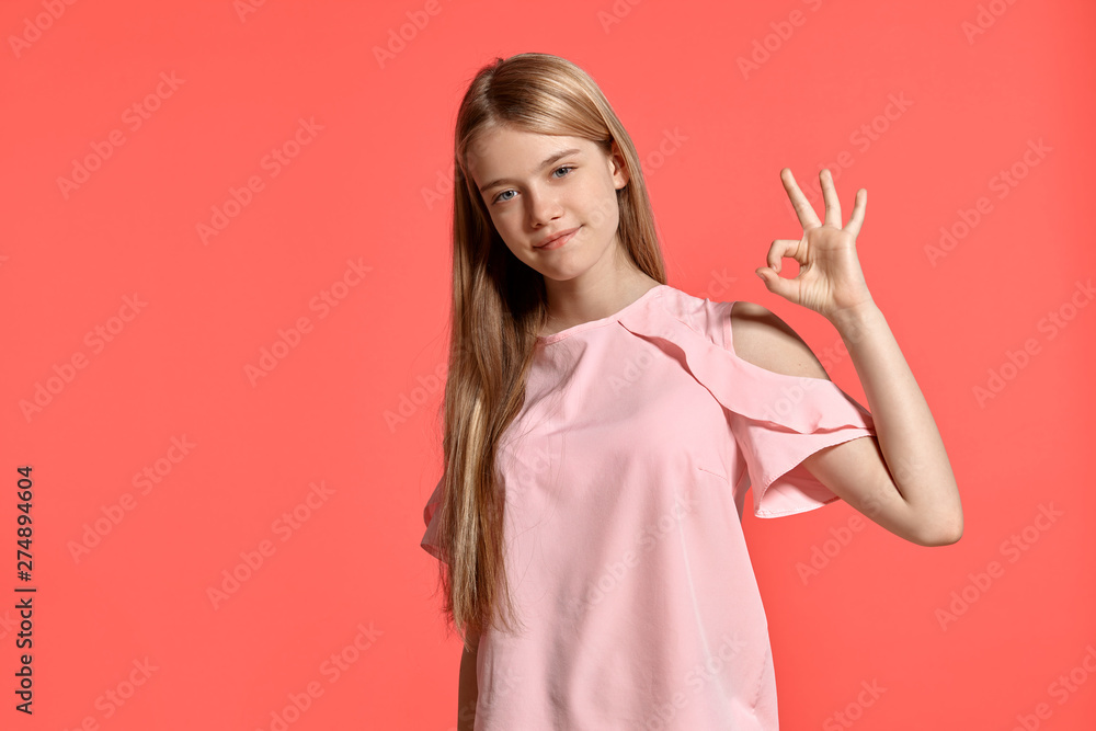 Studio portrait of a beautiful girl blonde teenager in a rosy t-shirt posing on pink background. Studio portrait of a beautiful girl blonde teenager in a rosy t-shirt posing on pink background.