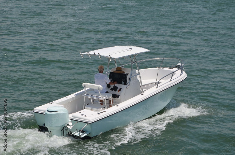 Small light blue and white sport fishing boat on the Florida Intra
