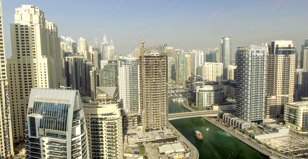 Obraz premium DUBAI - DECEMBER 5, 2016: Aerial view of Dubai Marina skyscrapers along artificial canal. Dubai attracts 15 million people annually