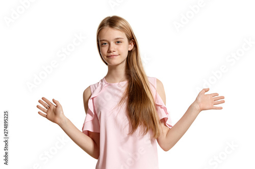 Studio portrait of a beautiful girl blonde teenager in a pink t-shirt posing isolated on white background. © nazarovsergey