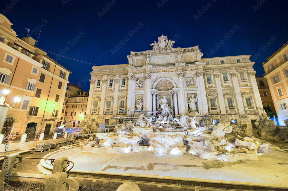 Naklejka premium ROME, ITALY - JUNE 2014: Tourists visit Trevi Fountain at dusk. The city attracts 15 million people annually