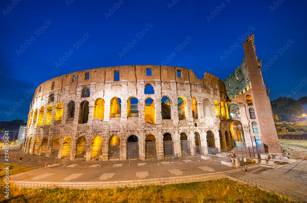 ROME, ITALY - JUNE 2014: Tourists visit Colosseum at night. The city attracts 15 million people annually