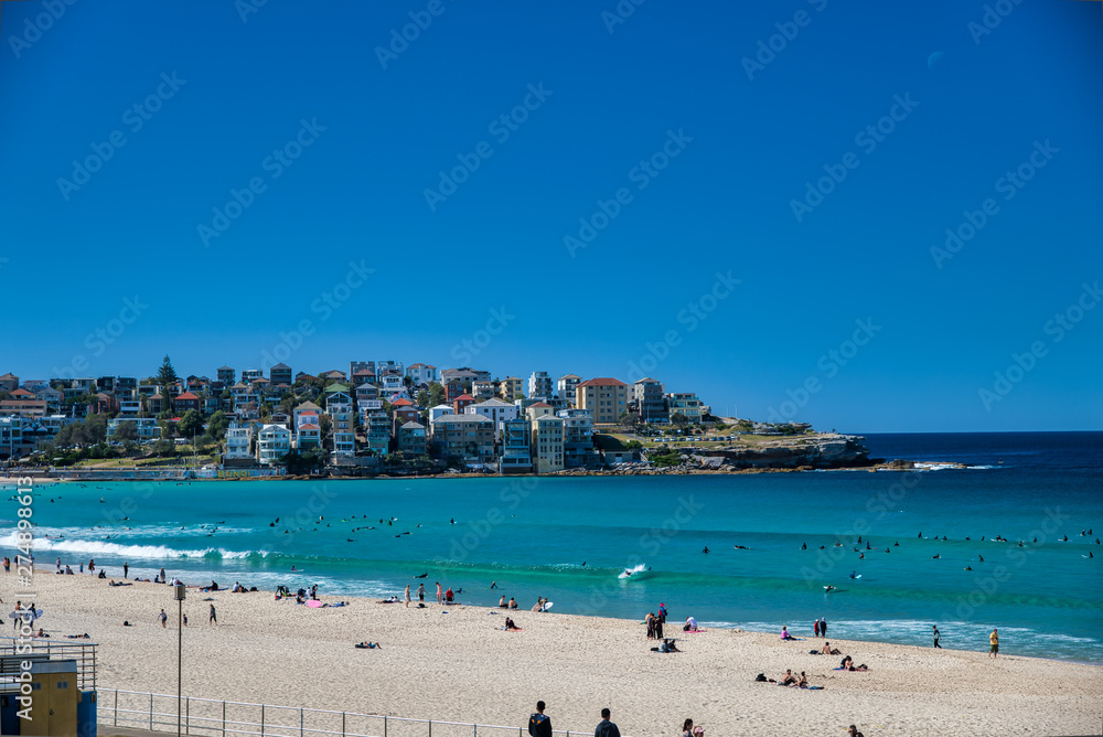BONDI BEACH, AUSTRALIA - AUGUST 18, 2018: Tourists visit coastline and beach. Bondi Beach is a famous tourist attraction