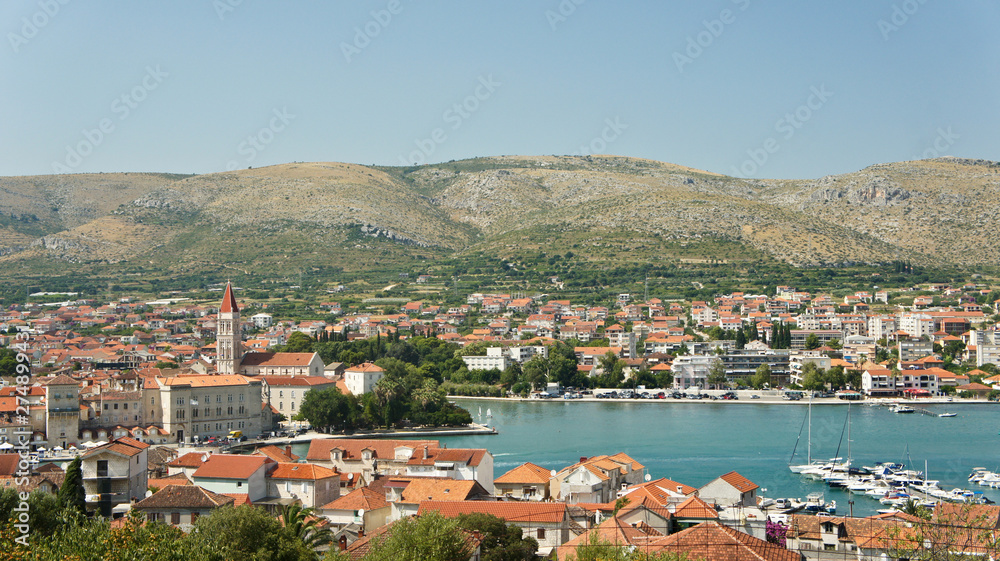 Scenic top view of the city with mountain background, beautiful cityscape with sea, sunny day, Trogir, Dalmatia, Croatia