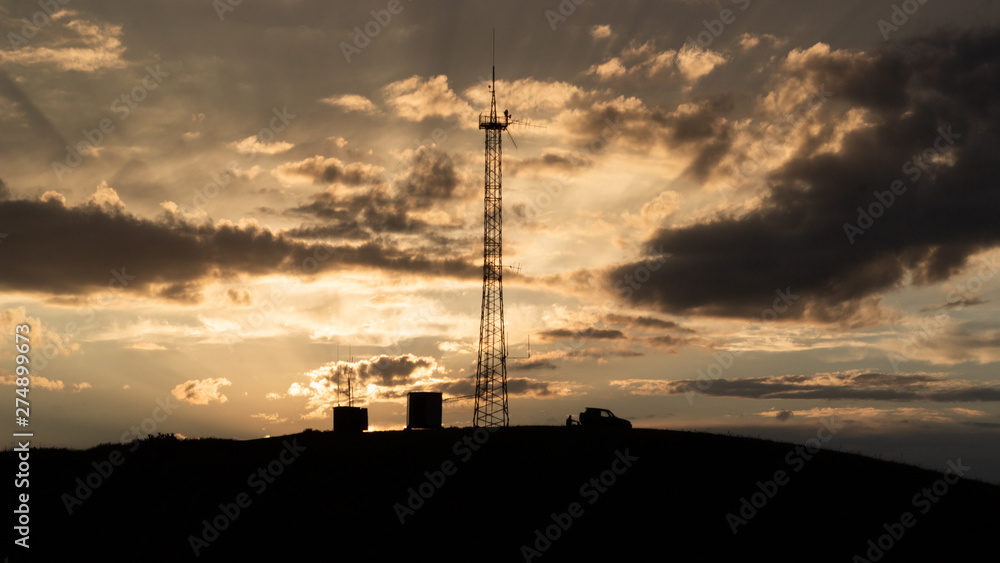 Silhouettes of a car, a man and a tower on a background of a sunset. Silhouettes of a car, a man and a tower on a background of a sunset.