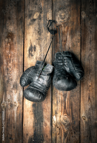 very old leather black boxing gloves hang © nndanko