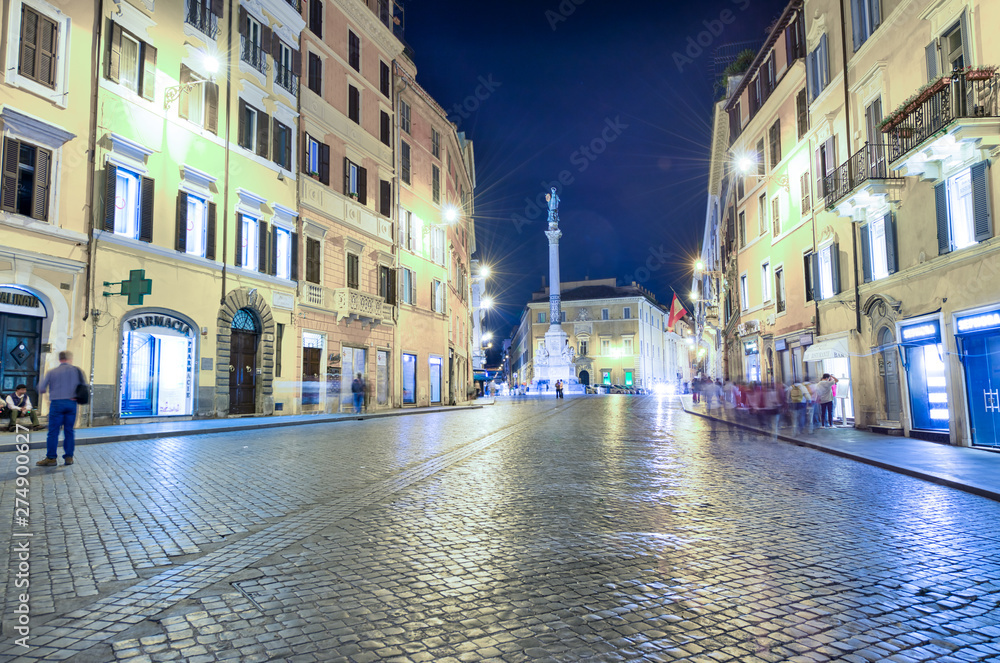 ROME, ITALY - JUNE 2014: Tourists visit city streets at dusk. The city attracts 15 million people annually