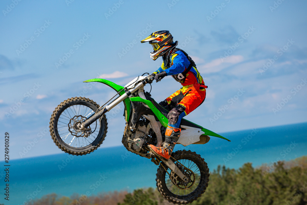 Biker does the trick and jumps in the air. Extreme concept, adrenaline. Copy space. Sky background Biker does the trick and jumps in the air. Extreme concept, adrenaline. Copy space. Sky background