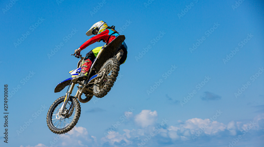 Biker does the trick and jumps in the air. Extreme concept, adrenaline. Copy space. Sky background Biker does the trick and jumps in the air. Extreme concept, adrenaline. Copy space. Sky background