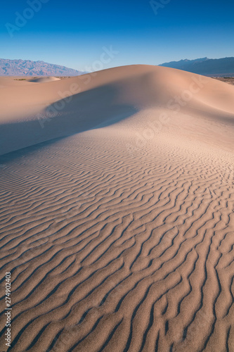 Early Morning Sunlight Over Sand Dunes And Mountains At  Mesquite flat dunes  Death Valley National Park  California USA Stovepipe Wells sand dunes  very nice structures in sand Beautiful background