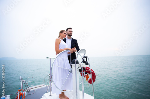 luxury business travelers are driving the boat yacht and showing their love for each other on a sailing boat. Concept business travel