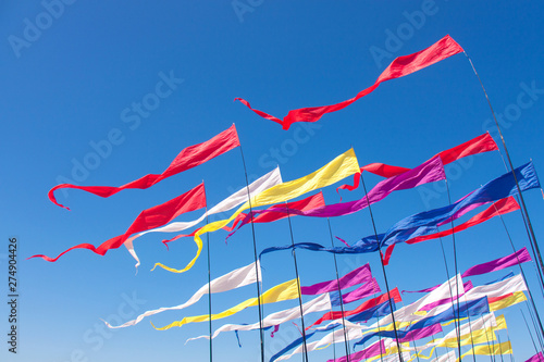 Multicolored kites in the blue sunny sky