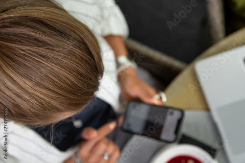 Businesswoman working during the lunch with salad sitting at the vegan restaurant on the beautiful green wall background