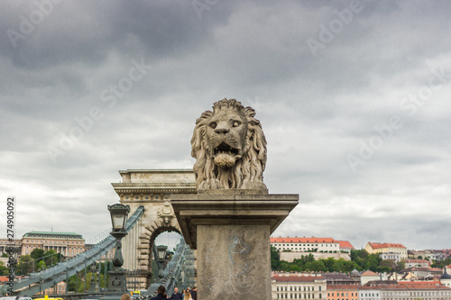 Lion statue. Stone monument. Monument near the castle. Medieval architecture. Historical heritage. Lions of Budapest. Travel to Hungary. European monuments to animals. Muzzle of a lion.