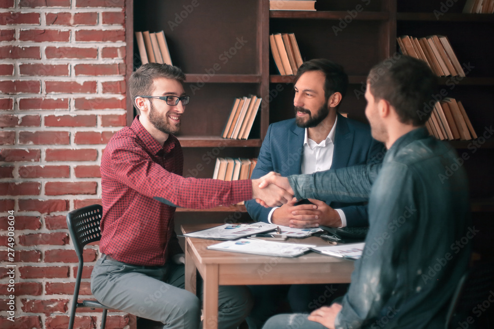 friendly handshake between Manager and client in creative office. friendly handshake between Manager and client in creative office.