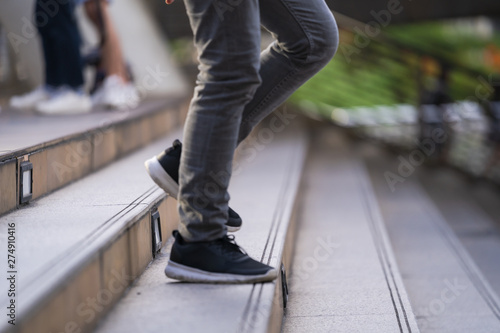 Close up of legs and shoes walking on street in the city