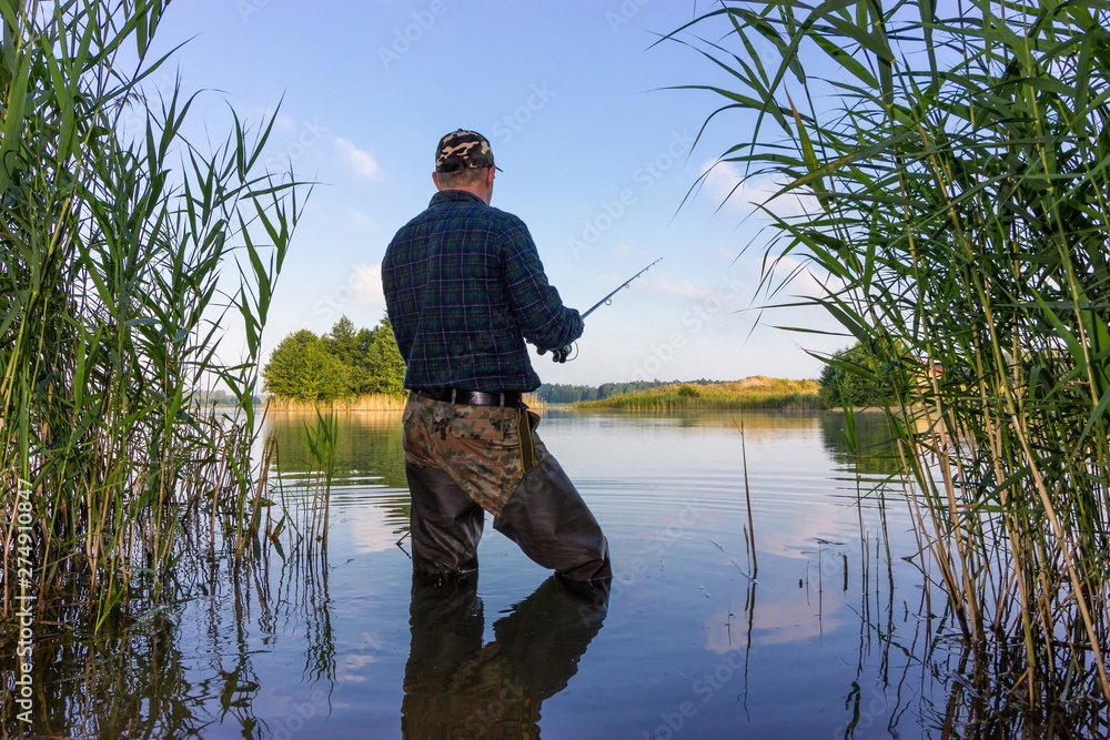 Angler catching the fish in the lake Angler catching the fish in the lake