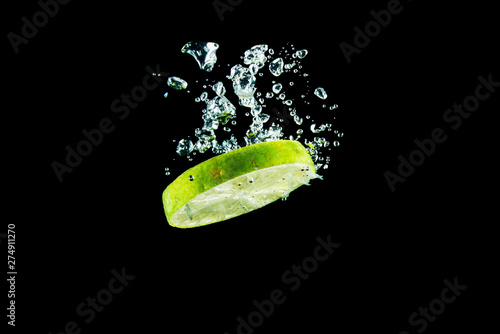 lime under water with splashes on a black background