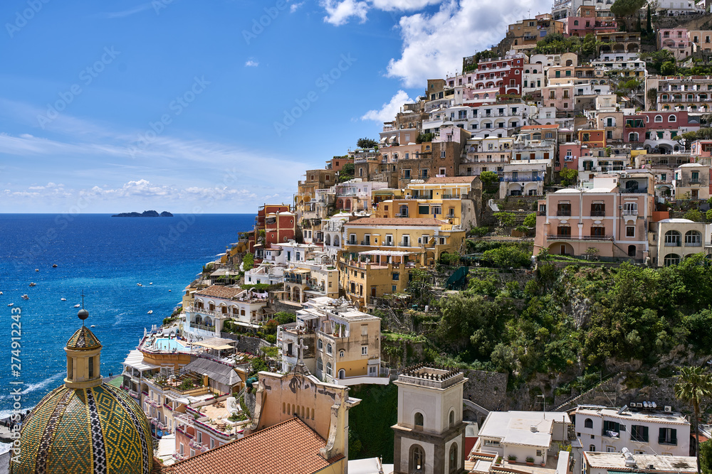 Colorful houses and church on coastline of Positano town in Italy
