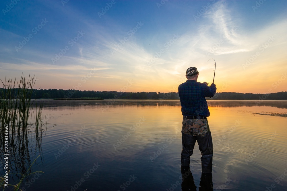 Angler catching the fish during sunrise