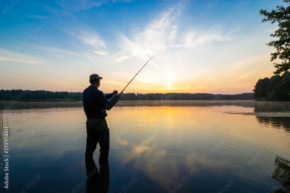 Silhouette of angler during sunrise