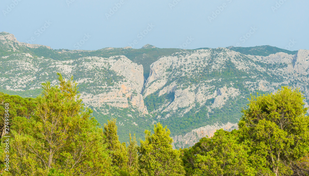 Scenic landscape of green hills and rocky mountains of the island of Sardinia in spring