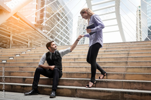 Businessman Assisting Businesswoman On Staircase