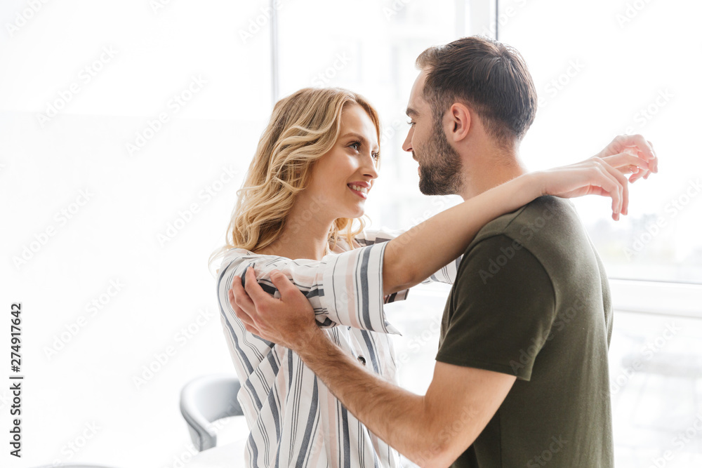 Fototapeta premium Loving couple posing at the kitchen at home hugging.