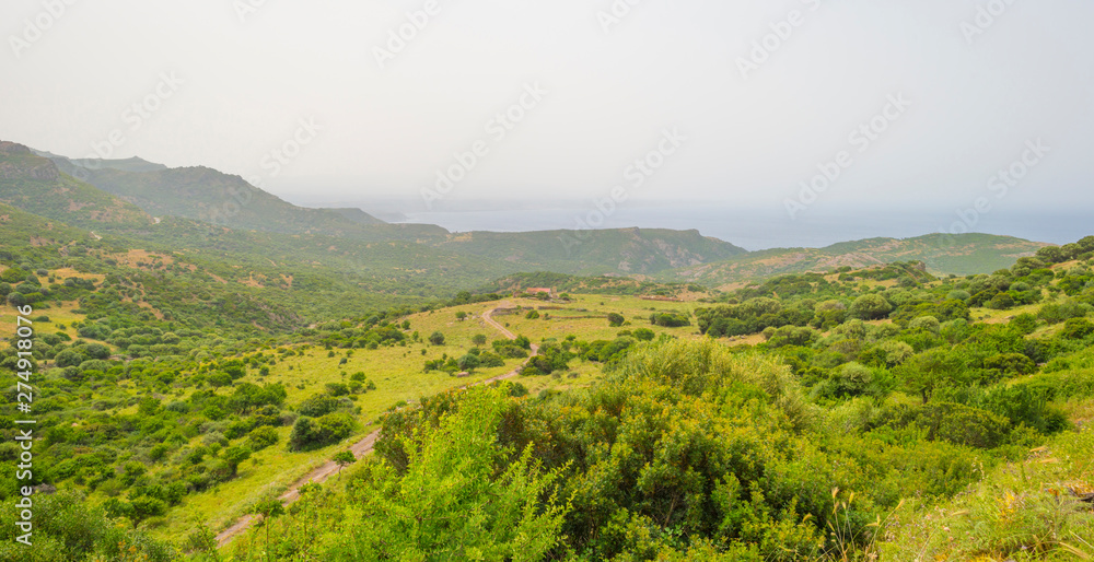 Scenic landscape of green hills and rocky mountains of the island of Sardinia in spring Scenic landscape of green hills and rocky mountains of the island of Sardinia in spring