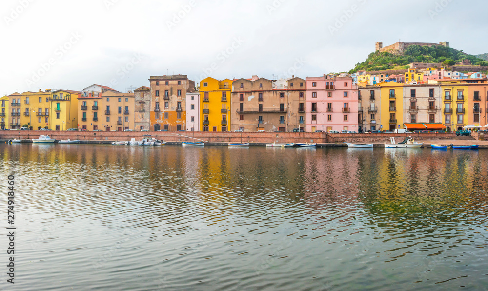 Obraz premium Panorama of the colorful town of Bosa along a river and hills in sunlight in spring