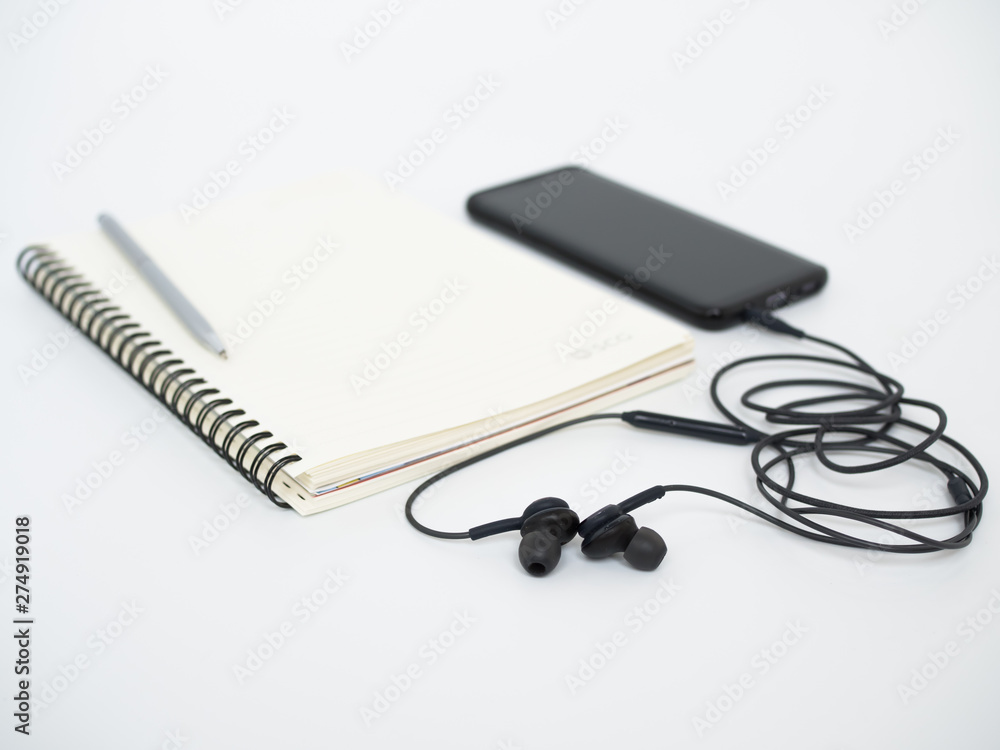 headphones and notebook with smartphone on white background headphones and notebook with smartphone on white background