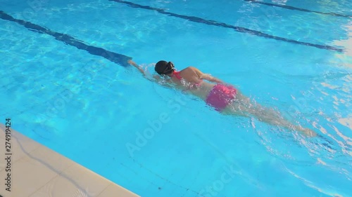 Middle aged woman swimming with out a cap,high angle view. Adult healthy female enjoy free style swimming in outdoor swimming pool with soft sunlight in the evening ,hd slow motion. 