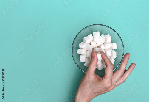 Foto Refined sugar cubes in a glass bowl, view from above