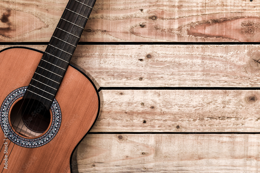 Obraz premium Acoustic guitar on vintage style wood background. Copy space with musical guitar instrument
