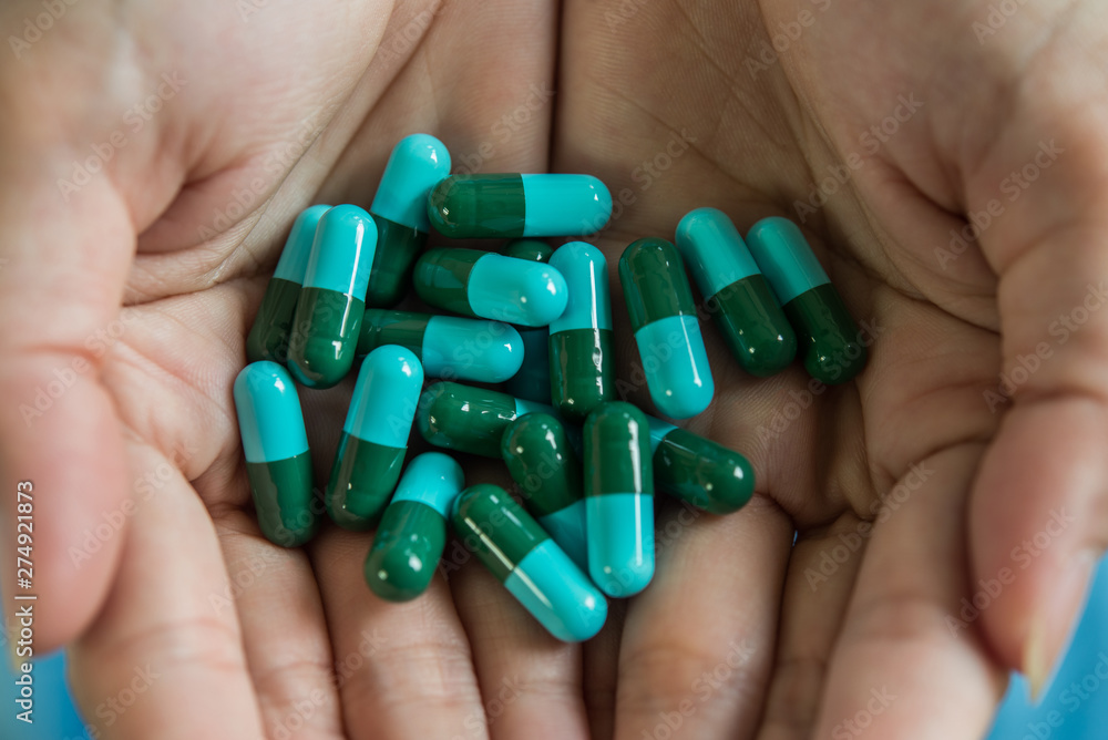 Woman's hand pours the medicine pills out of the bottle Woman's hand pours the medicine pills out of the bottle